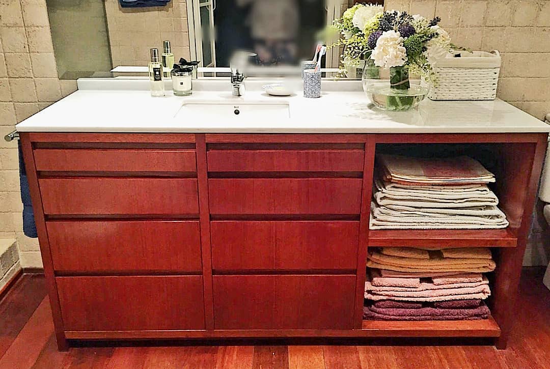 Mueble de baño en madera teñido y encimera de mármol. Careba